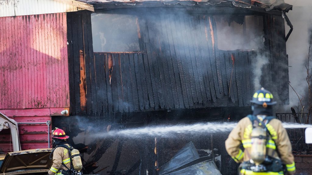 Fire fighters spraying water on fire